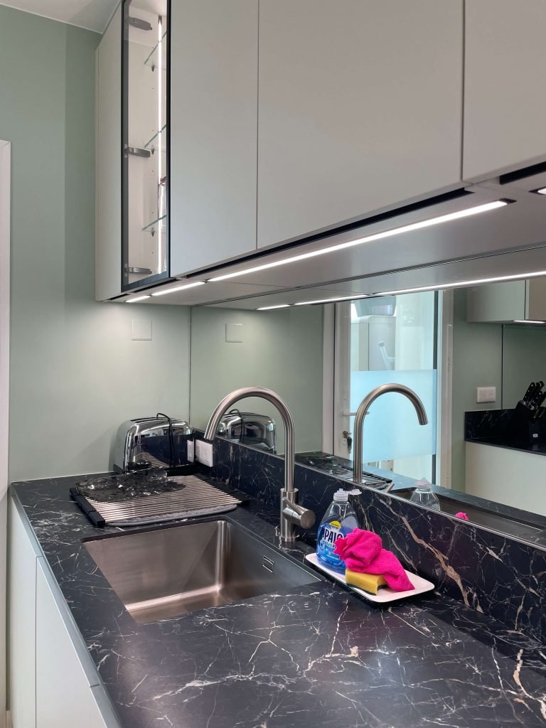 Evier sur plan de travail effet marbre noir. Conception agencement par Idea Mobilier