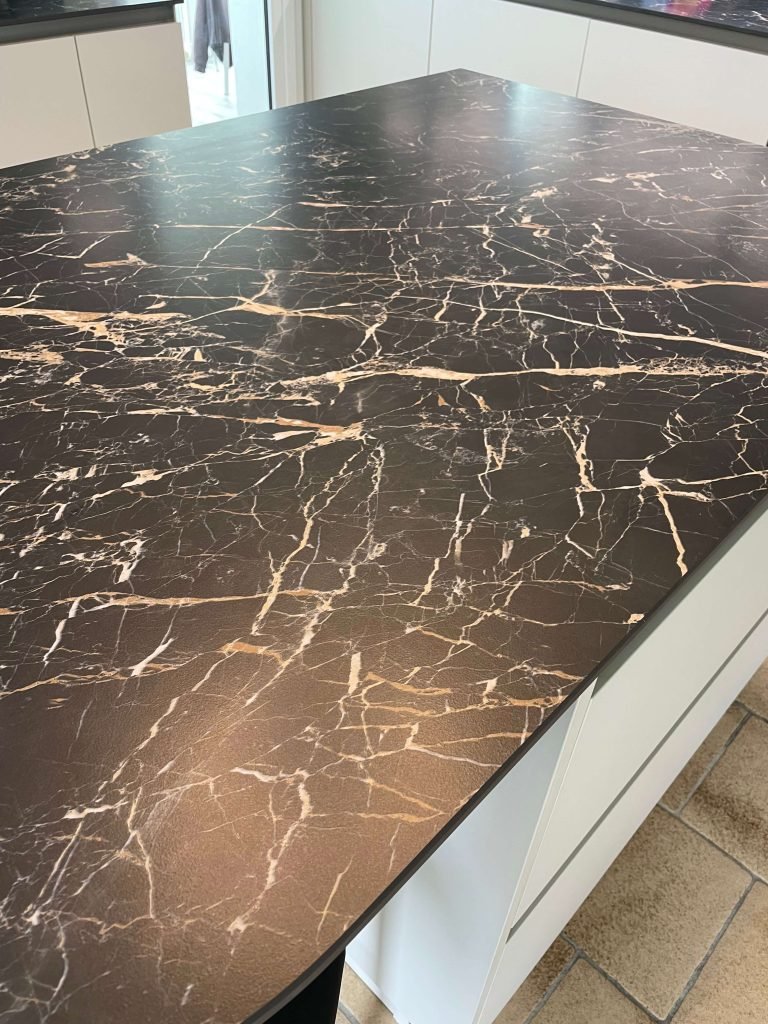 Plan de travail effet marbre noir pour une cuisine. Conception agencement par Idea Mobilier